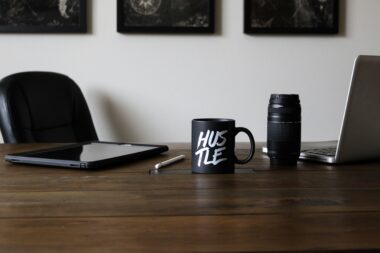 Work desk with a mug that says "Hustle"