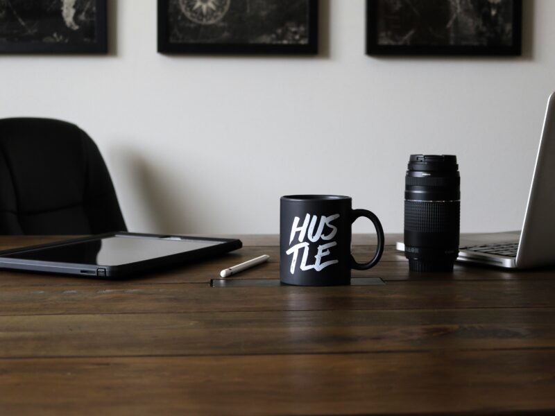 Work desk with a mug that says "Hustle"